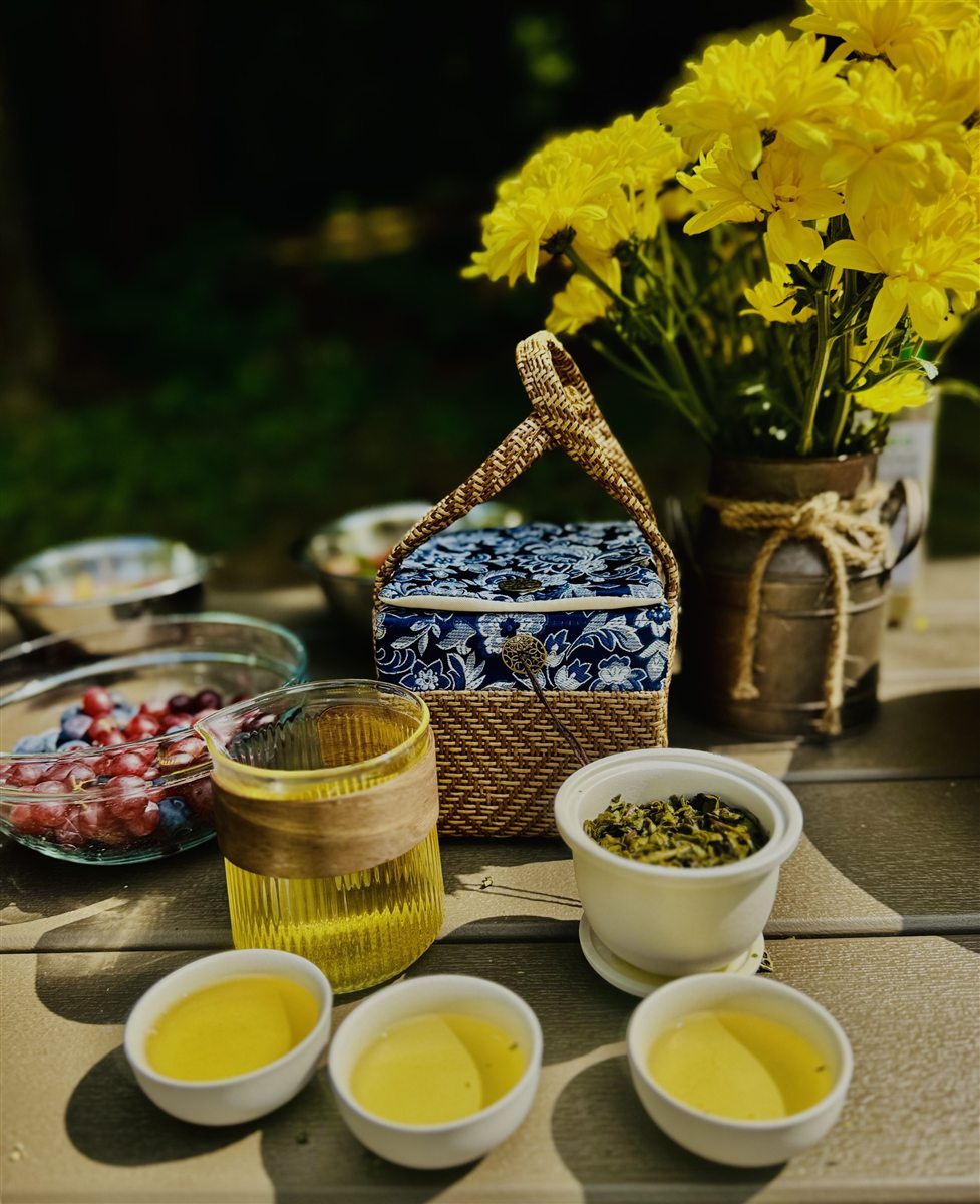 Tea cups, brewed tea, loose leaves, and flowers arranged for a tea moment